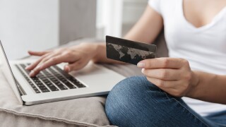 Woman with laptop and credit card doing online shopping